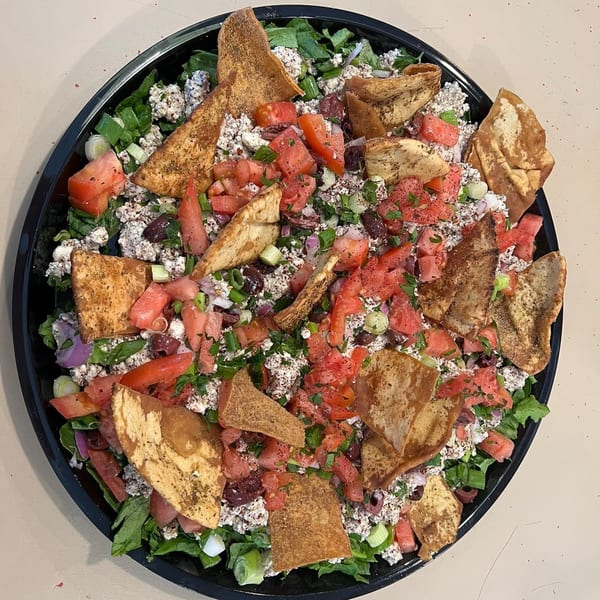 Dalia's Mediterranean salad with lettuce, tomatoes, feta, olives, green onions, and pita chips.